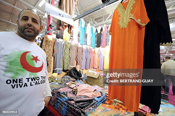 Man stands by a fashion stall during the annual meeting of French Muslims organized by the Union of Islamic Organisations of France in Le Bourget,...