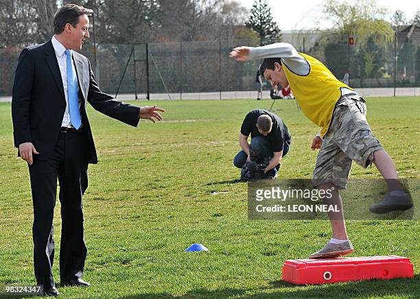 British Opposition Conservative Party leader David Cameron reacts as a student takes part in a "Ready, Steady Go" team-building exercise during an...