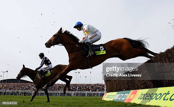 What A Friend ridden by Ruby Walsh clears a fence alongside Imperial Commander ridden by Paddy Brennan on their way to victory in The totesport Bowl...