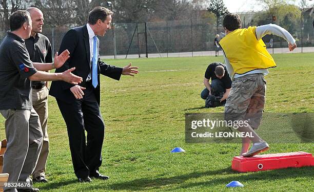 British Opposition Conservative Party leader David Cameron reacts as a student takes part in a "Ready, Steady Go" team-building exercise during an...
