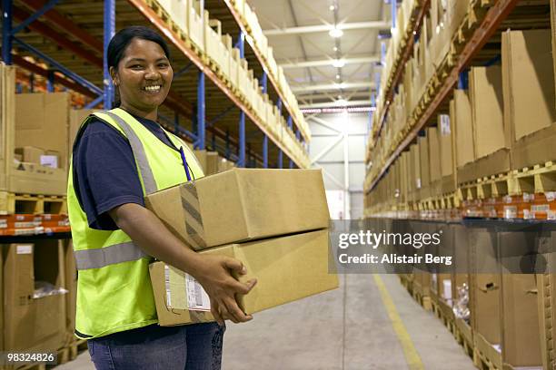 warehouse worker holding box - newbusiness stock pictures, royalty-free photos & images