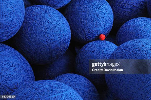 large blue woolen balls with one small red one. - big small stock-fotos und bilder