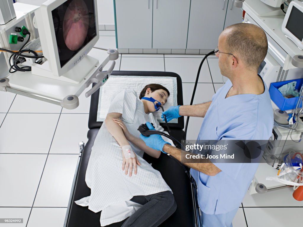 Doctor examing young woman with endoscope