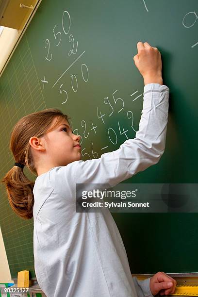 young girl writing on a blackboard - child writing on chalkboard stock pictures, royalty-free photos & images