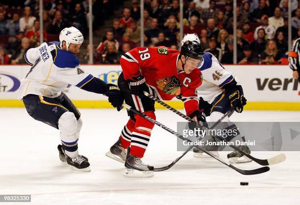Jonathan Toews of the Chicago Blackhawks skates up the ice between Eric Brewer and Roman Polak of the St. Louis Blues at the United Center on April...