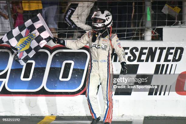 Justin Haley driving a Chevrolet for the Fraternal Order of Eagles waves the checkered flag in celebration after winning the NASCAR Camping World...