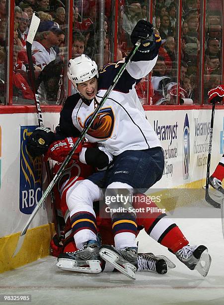 Colby Armstrong of the Atlanta Thrashers gets tangled up along the boards during their NHL game against the Carolina Huricanes on March 27, 2010 at...