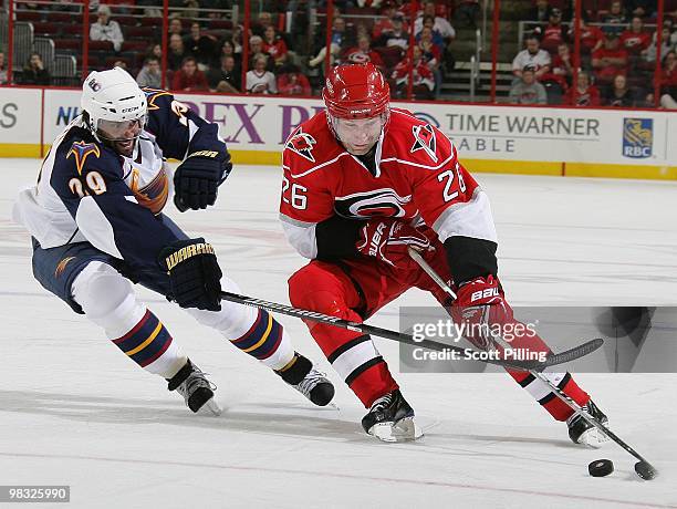 Erik Cole of the Carolina Hurricanes battles for the puck with Johnny Oduya of the Atlanta Thrashers during their NHL game on March 27, 2010 at the...