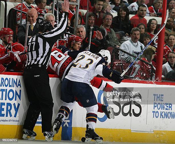 Erik Cole of the Carolina Hurricanes gets checked into his team's bench by Jim Slater of the Atlanta Thrashers during their NHL game on March 27,...