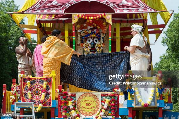 Hare Krishna devotees unveil the statue of a deity placed on a wooden chariot ahead of the annual Rathayatra procession through central London....