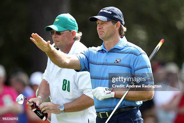 Retief Goosen of South Africa talks with his caddie Mark Pittock on the first hole during the first round of the 2010 Masters Tournament at Augusta...