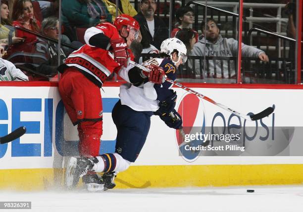 Joni Pitkanen of the Carolina Hurricanes battles for the puck along the boards with Clarke MacArthur of the Atlanta Thrashers during their NHL game...