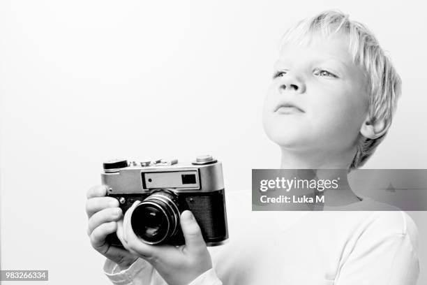 young blonde hair boy holding retro vintage lomo rangefinder cam - lomo camera stock pictures, royalty-free photos & images