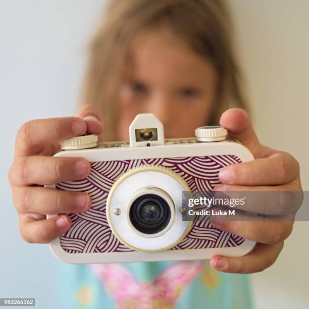 young light haired girl holding plastic lomo retro film camera - lomo camera stock pictures, royalty-free photos & images