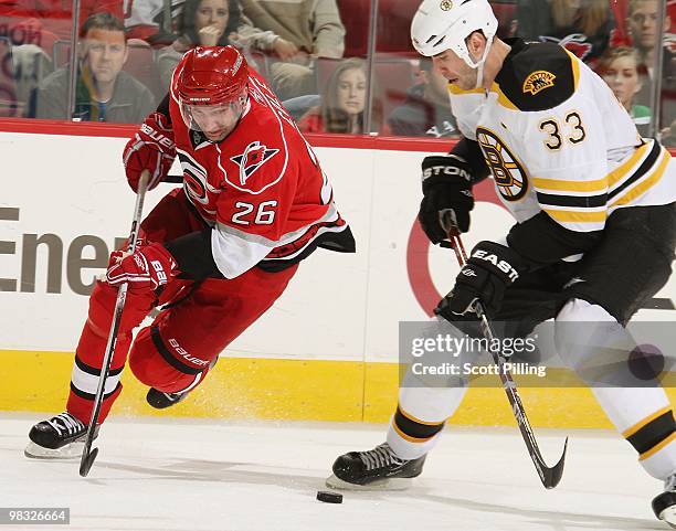 Erik Cole of the Carolina Hurricanes races for the puck against Zdeno Chara of the Boston Bruins during their NHL game on March 16, 2010 at the RBC...
