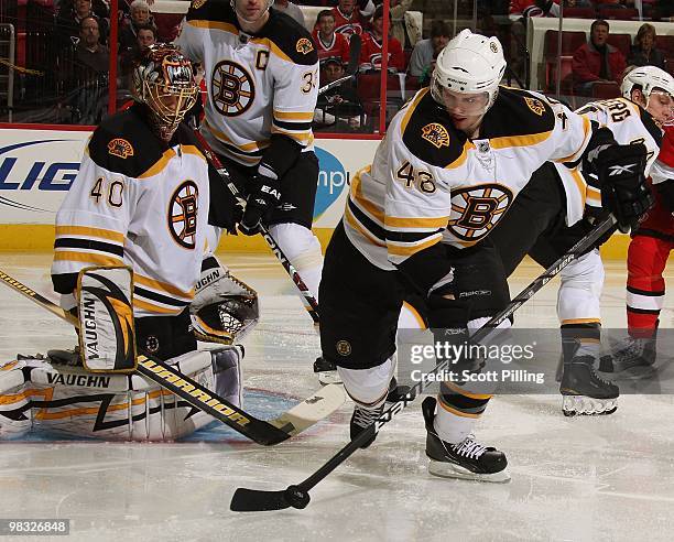 David Krejci of the Boston Bruins clears the puck after rebounding off his goalie during their NHL game against the Carolina Hurricanes on March 16,...