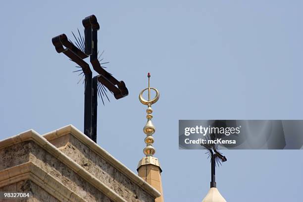 two christian crosses, one islamic spire against blue sky - ecumenism stock pictures, royalty-free photos & images