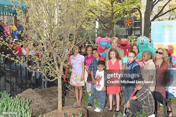 Anchorwoman Katie Couric appears with Sesame Street Muppets Jesse, Elmo and Rosita and children coping with the death of a parent for a special tree...