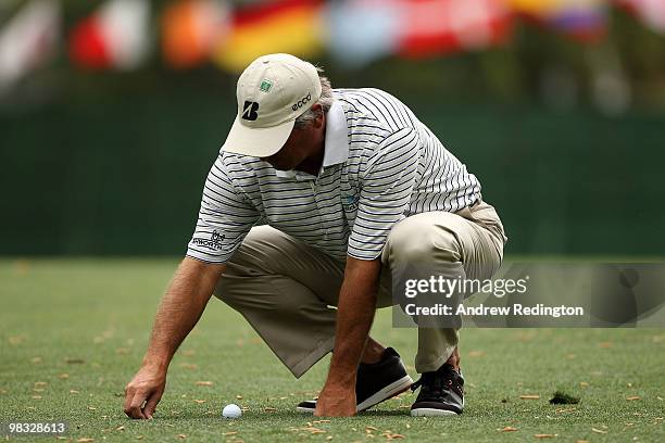 Fred Couples picks up some loose impediments on the first hole during the first round of the 2010 Masters Tournament at Augusta National Golf Club on...