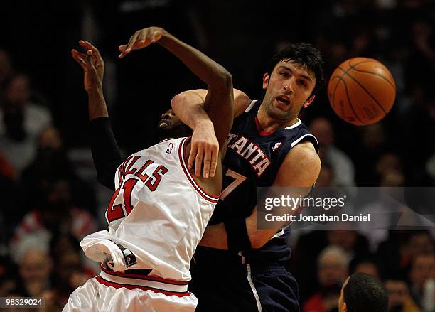 Zaza Pachulia of the Atlanta Hawks gets tangled up with Hakim Warrick of the Chicago Bulls as they battle for a rebound at the United Center on March...