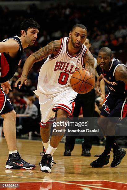 Acie Law of the Chicago Bulls drives between Zaza Pachulia and Jamal Crawford of the Atlanta Hawks at the United Center on March 1, 2010 in Chicago,...