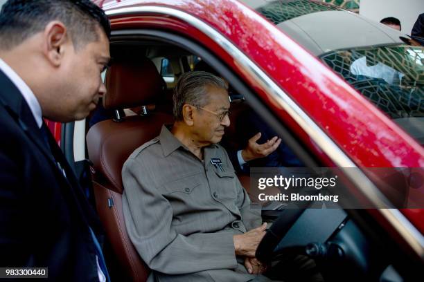 Mahathir Mohamad, Malaysias prime minister sits in a Proton Holdings Bhd sport utility vehicle before taking a test drive in Kuala Lumpur, Malaysia,...