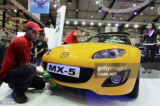 Workers wipe fingerprints from an MX-5 at the Lebanon Motor Show 2010 in Beirut on April 8, 2010. The show features the latest vehicles from around...