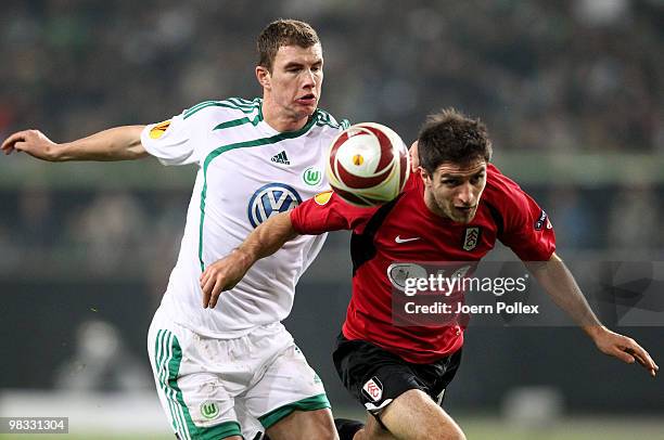 Edin Dzeko of Wolfsburg and Aaron Hughes of Fulham compete for the ball during the UEFA Europa League quarter final second leg match between VfL...