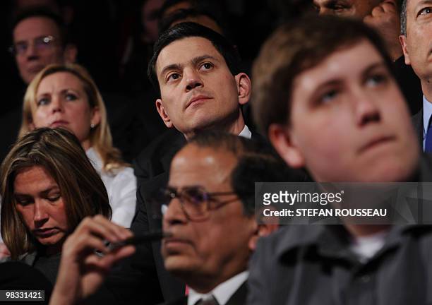 Foreign Secretary David Miliband watches unseen British Prime Minister Gordon Brown speak to economists at the Michael Faraday Theatre in London...