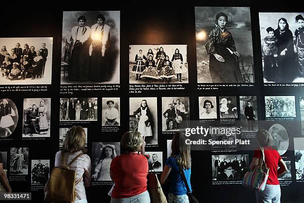 Group of woman look at historic images of immigrants at a museum on Ellis island on April 8, 2010 in New York, New York. The nonprofit in charge of...