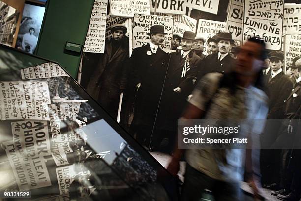 Man walks by historic images of immigrants at a museum on Ellis Island on April 8, 2010 in New York, New York. The nonprofit in charge of restoring...