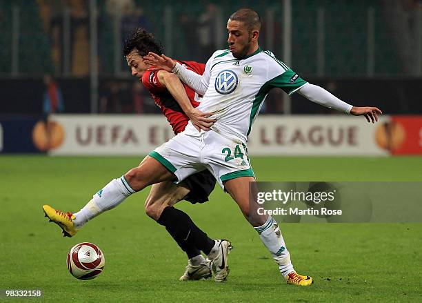 Ashkan Dejagah of Wolfsburg and Simon Davies of Fulham compete for the ball during the UEFA Europa League quarter final second leg match between VfL...