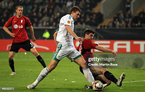 Edin Dzeko of Wolfsburg and Zoltan Gera of Fulham compete for the ball during the UEFA Europa League quarter final second leg match between VfL...