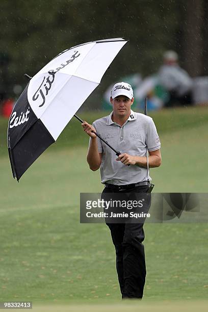 Nick Watney walks under an umbrella to the 17th green during the first round of the 2010 Masters Tournament at Augusta National Golf Club on April 8,...
