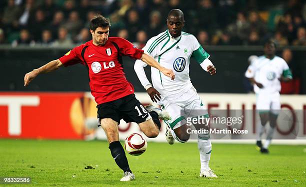 Grafite of Wolfsburg and Aaron Hughes of Fulham compete for the ball during the UEFA Europa League quarter final second leg match between VfL...