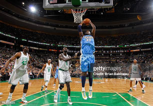 Johan Petro of the Denver Nuggets makes a move to the basket against Kevin Garnett of the Boston Celtics during the game at The TD Garden on March...