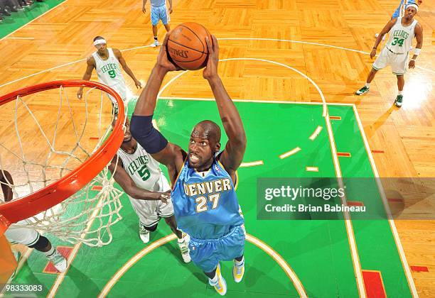 Johan Petro of the Denver Nuggets makes a move to the basket against Kevin Garnett of the Boston Celtics during the game at The TD Garden on March...