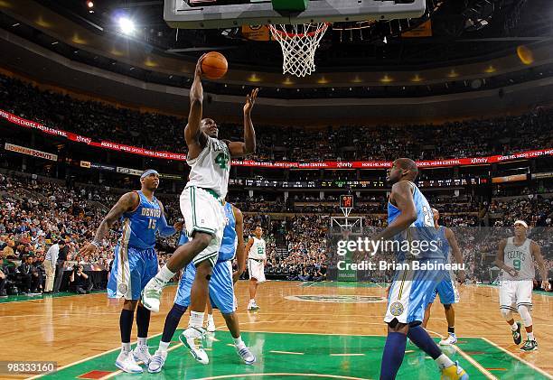 Tony Allen of the Boston Celtics goes up for a shot against Carmelo Anthony and Johan Petro of the Denver Nuggets during the game at The TD Garden on...