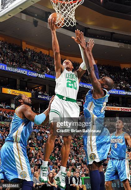 Ray Allen of the Boston Celtics shoots a layup against Nene and Johan Petro of the Denver Nuggets during the game at The TD Garden on March 24, 2010...