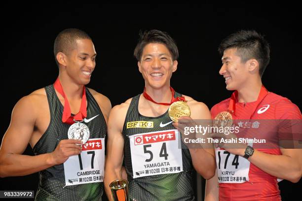 Second place Aska Cambridge, winner Ryota Yamagata and third place Yoshihide Kiryu pose during the medal ceremony for the Men's 100m on day two of...