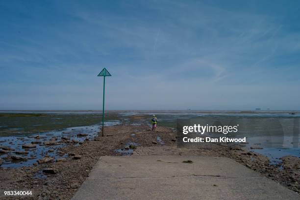 Walker leaves the mainland across 'The Broomway' on June 24, 2018 in Shoeburyness, England. The Broomway is a 'Byway' which leaves the Essex shore at...