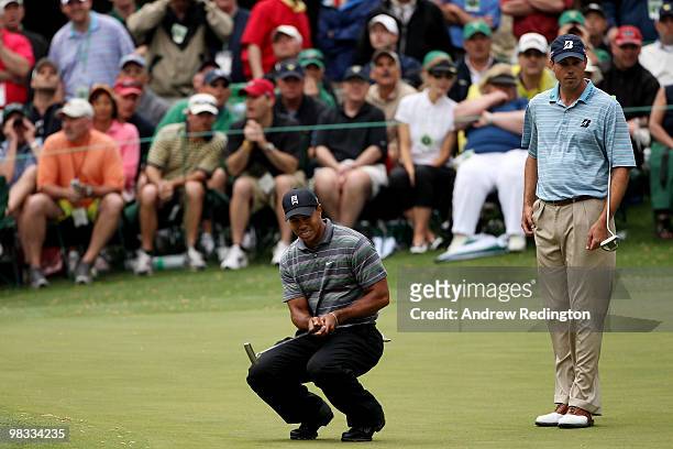 Tiger Woods reacts to a missed putt on the 16th hole while Matt Kuchar looks on during the first round of the 2010 Masters Tournament at Augusta...