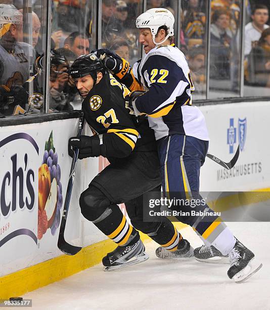 Adam Mair of the Buffalo Sabres checks Steve Begin of the Boston Bruins at the TD Garden on April 8, 2010 in Boston, Massachusetts.