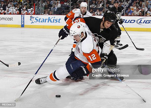 Mark Eaton of the Pittsburgh Penguins battles for the puck against Josh Bailey of the New York Islanders on April 8, 2010 at Mellon Arena in...