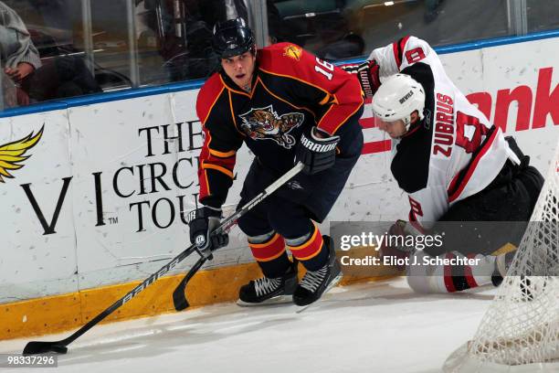 Nathan Horton of the Florida Panthers digs the puck out from the boards against Dainius Zubrus of the New Jersey Devils at the BankAtlantic Center on...