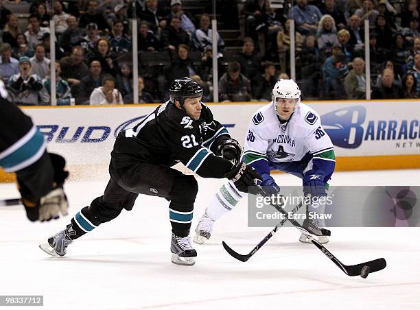 Scott Nichol of the San Jose Sharks and Jannik Hansen of the Vancouver Canucks go for the puck at HP Pavilion on April 8, 2010 in San Jose,...