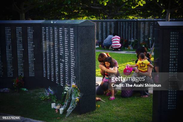 People prays in front of the Cornerstone of Peace where the names of their bereaved family members and relatives engraved at the Peace Memorial Park...