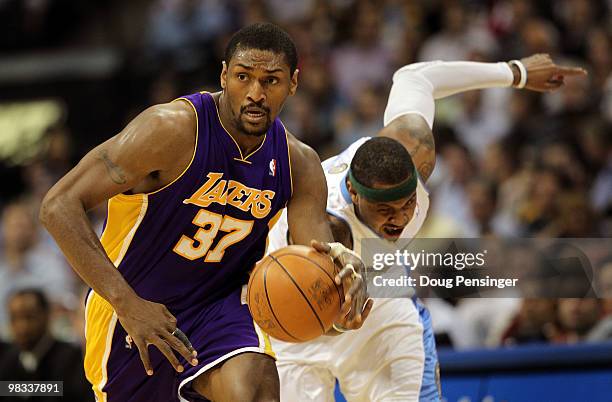 Ron Artest of the Los Angeles Lakers collects a loose ball and dribbles away from Carmelo Anthony of the Denver Nuggets during NBA action at the...