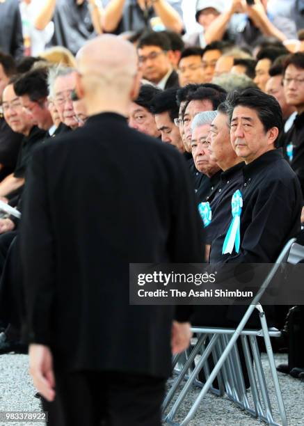 Okinawa Prefecture Governor Takeshi Onaga walks to the stage prior to addressing while Prime Minister Shinzo Abe looks on during the memorial...