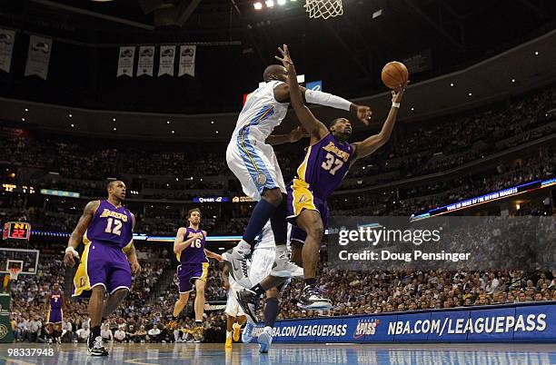 Ron Artest of the Los Angeles Lakers is fouled by Johan Petro of the Denver Nuggets as he puts up a shot during NBA action at the Pepsi Center on...